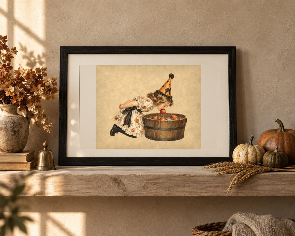 Vintage Halloween apple bobbing print in a black frame on an oak shelf with heirloom pumpkins