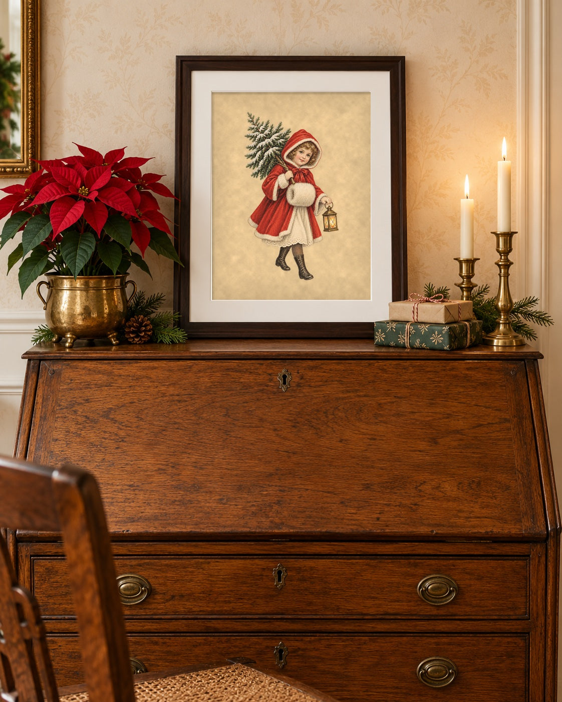 Framed antique Christmas print on an oak secretary desk with poinsettia and candles