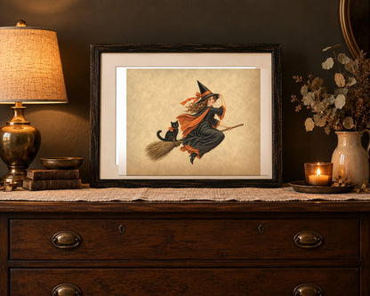 Vintage Halloween witch print framed on a bedroom dresser with a brass lamp