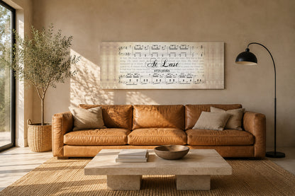 At Last by Etta James song lyrics canvas hung above a camel leather sofa in a warm sunlit living room with an olive tree and jute rug