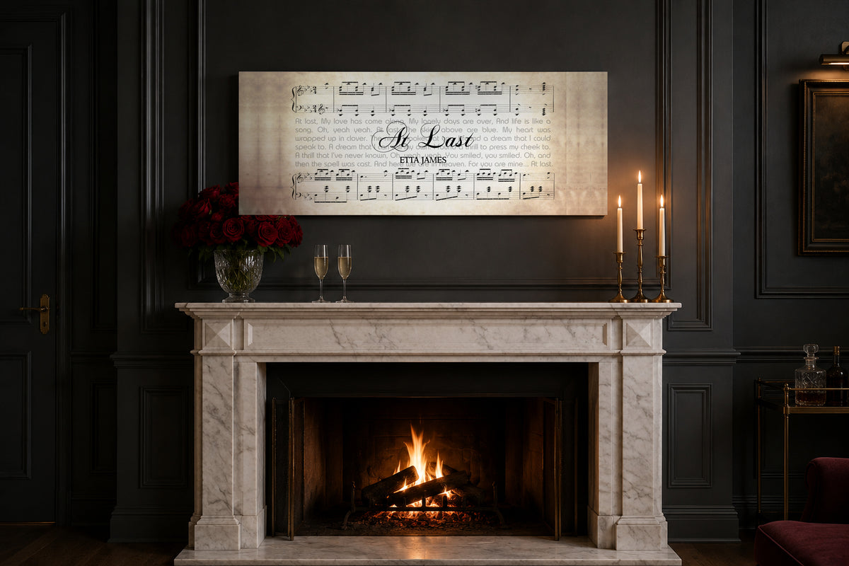 At Last song lyrics canvas above a white marble mantel with red roses, champagne flutes and lit brass tapers for an anniversary