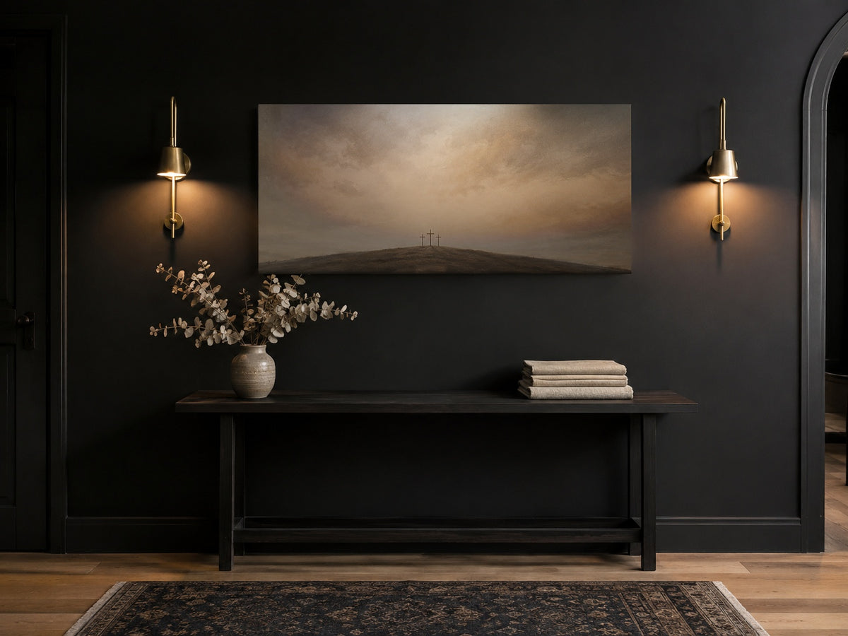 Three Crosses at Calvary canvas in a black entryway with brass sconces and console table