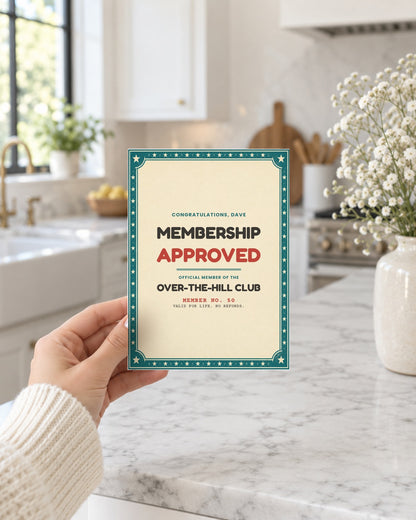 Hand holding the membership approved birthday card in a bright kitchen