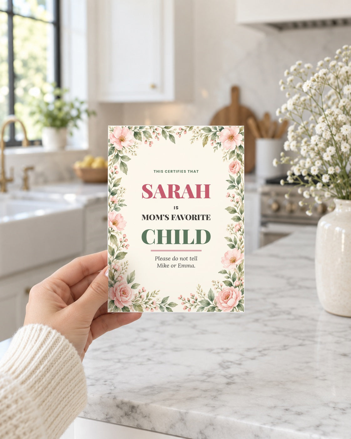 Hand holding the favorite child card in a bright kitchen