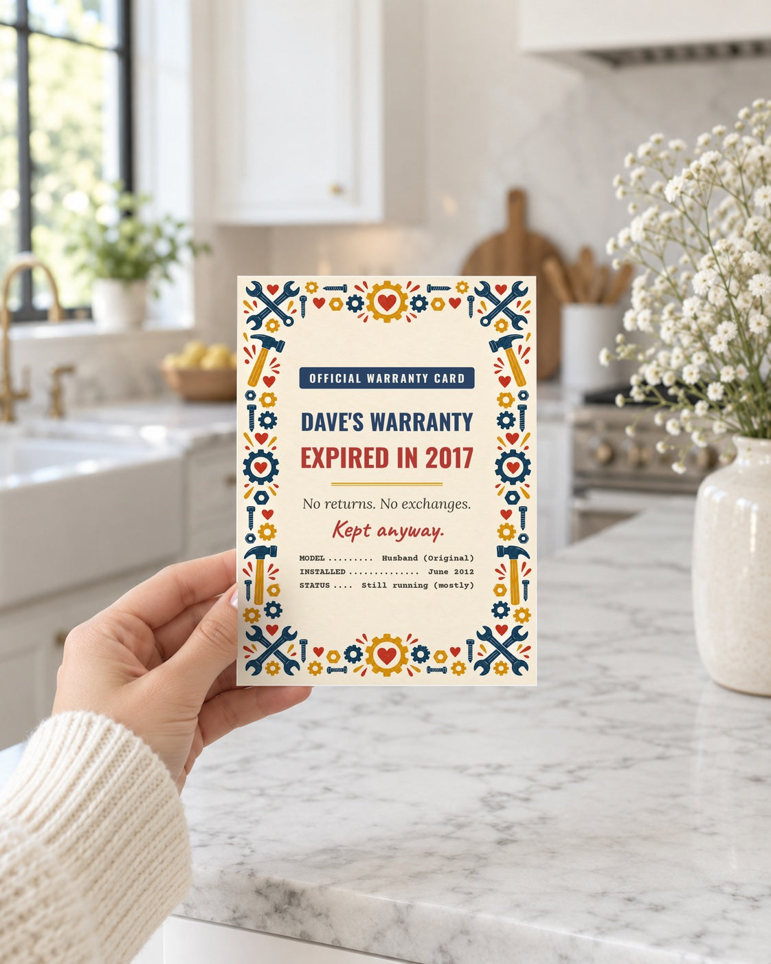 Hand holding the husband warranty card in a bright kitchen