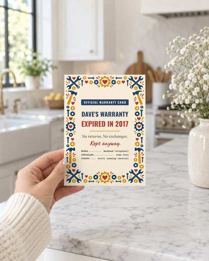 Hand holding the husband warranty card in a bright kitchen