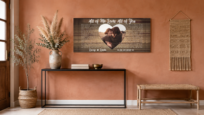 Couple song lyrics wall art on a terracotta boho entryway wall above a black console with pampas grass