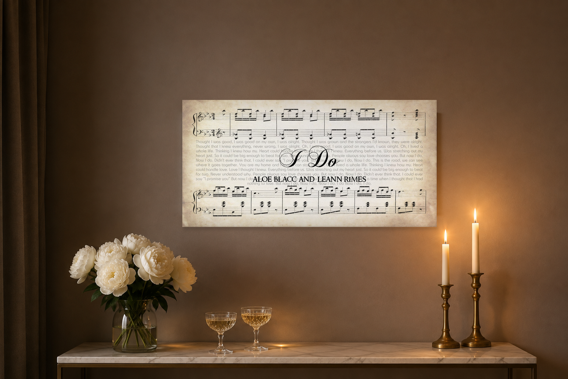 I Do song lyrics canvas above a marble console with white peonies, champagne coupes and brass taper candles at night