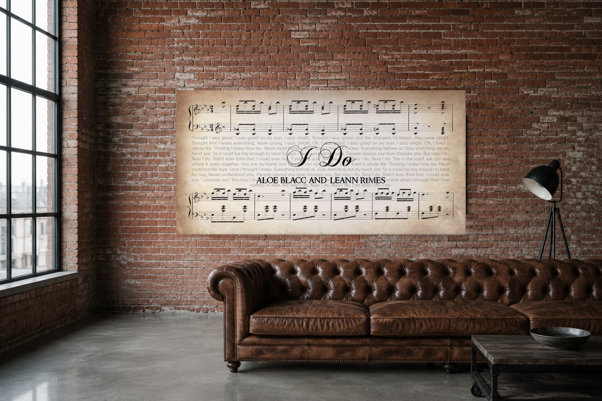 I Do song lyrics canvas on an exposed red brick loft wall above a cognac leather chesterfield sofa