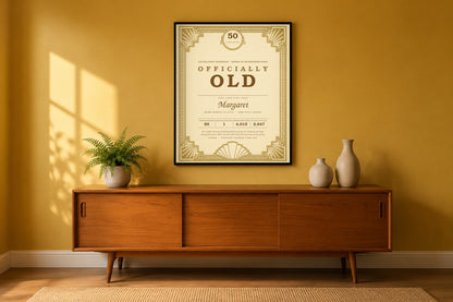 Personalized funny 50th birthday certificate framed on a mustard living room wall