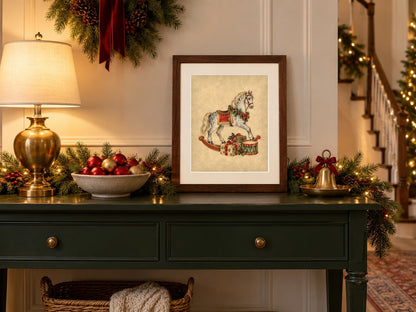 Vintage Christmas rocking horse print framed on a green entry console with ornaments