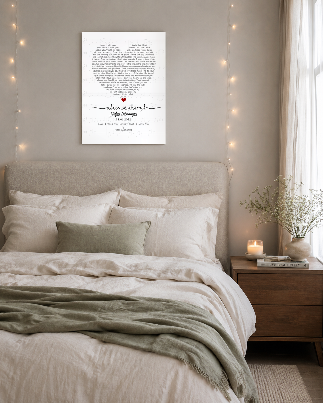 Custom heart shaped song lyrics wall art above a linen bed with string lights and candle in a serene master bedroom