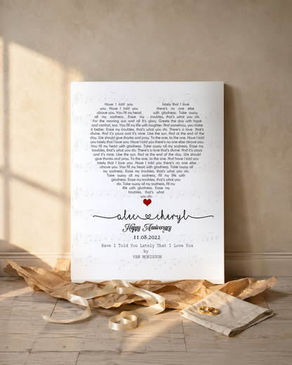 Personalized song lyrics canvas unwrapped as an anniversary gift with kraft paper, satin ribbon and gold wedding rings