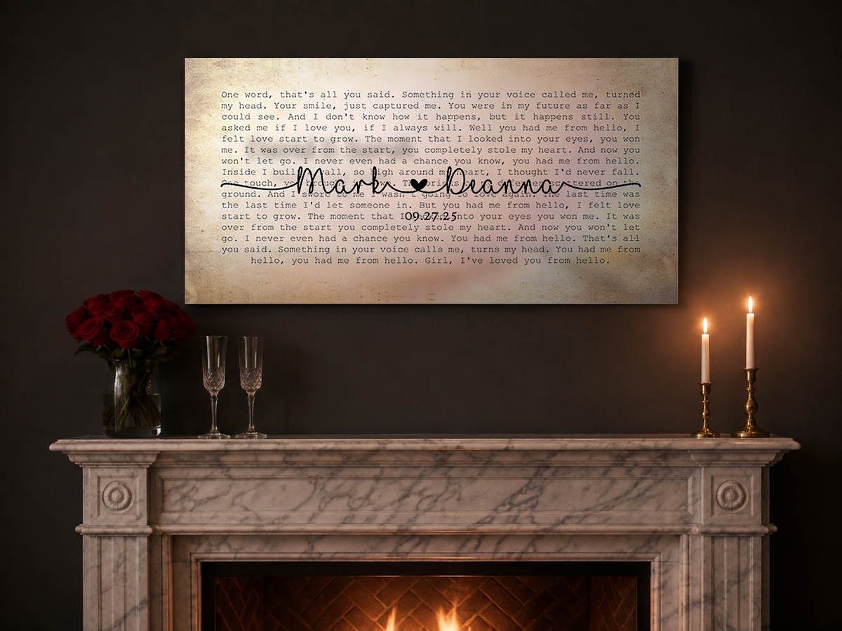 Personalized couple song lyrics canvas above a white marble mantel with red roses, champagne flutes and lit brass tapers for an anniversary