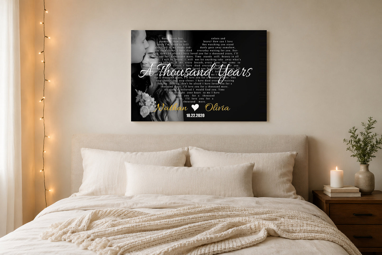 Custom song lyrics canvas hanging above a linen bed in a serene cream master bedroom with string lights and a candle