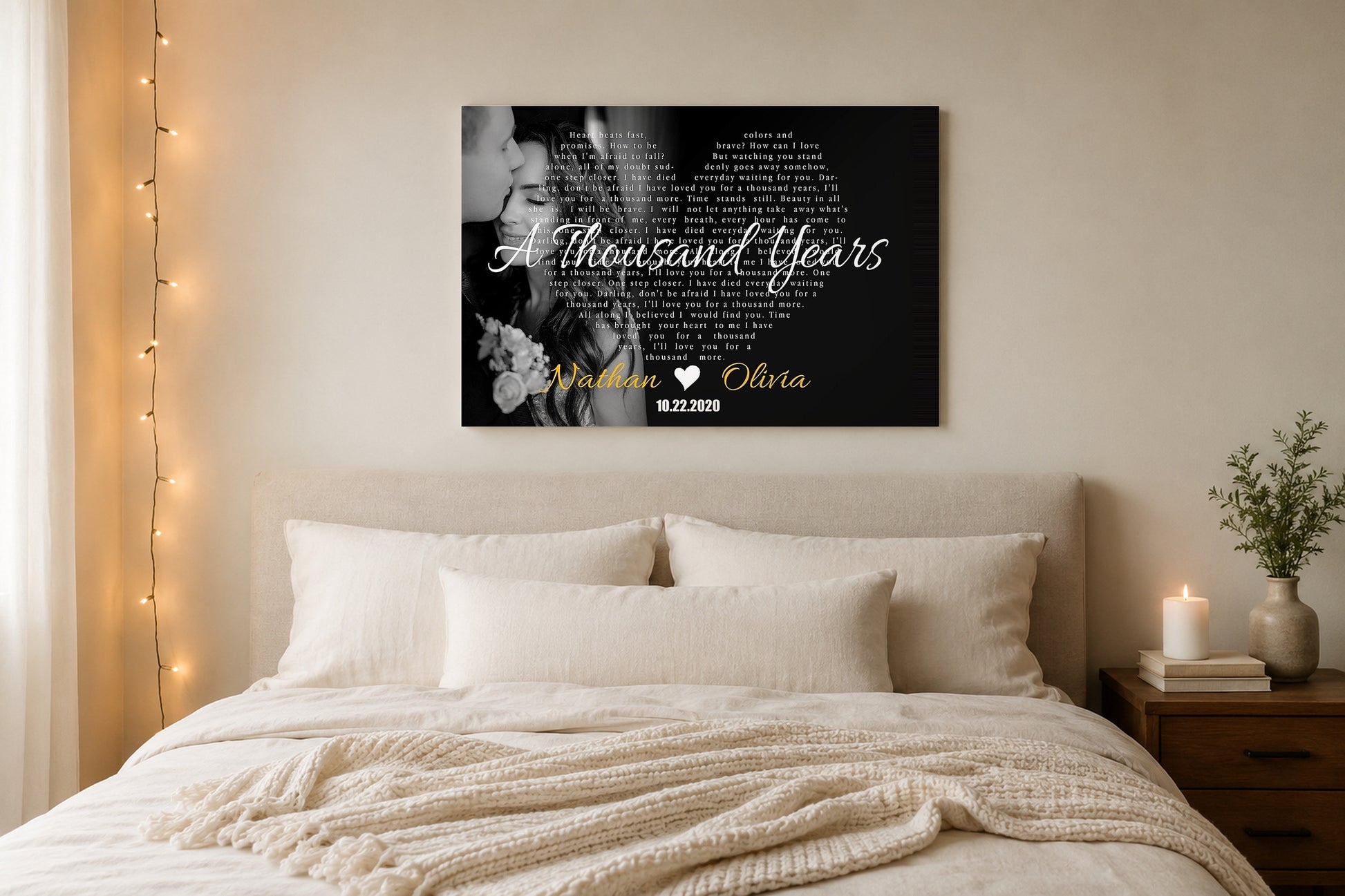 Custom song lyrics canvas hanging above a linen bed in a serene cream master bedroom with string lights and a candle