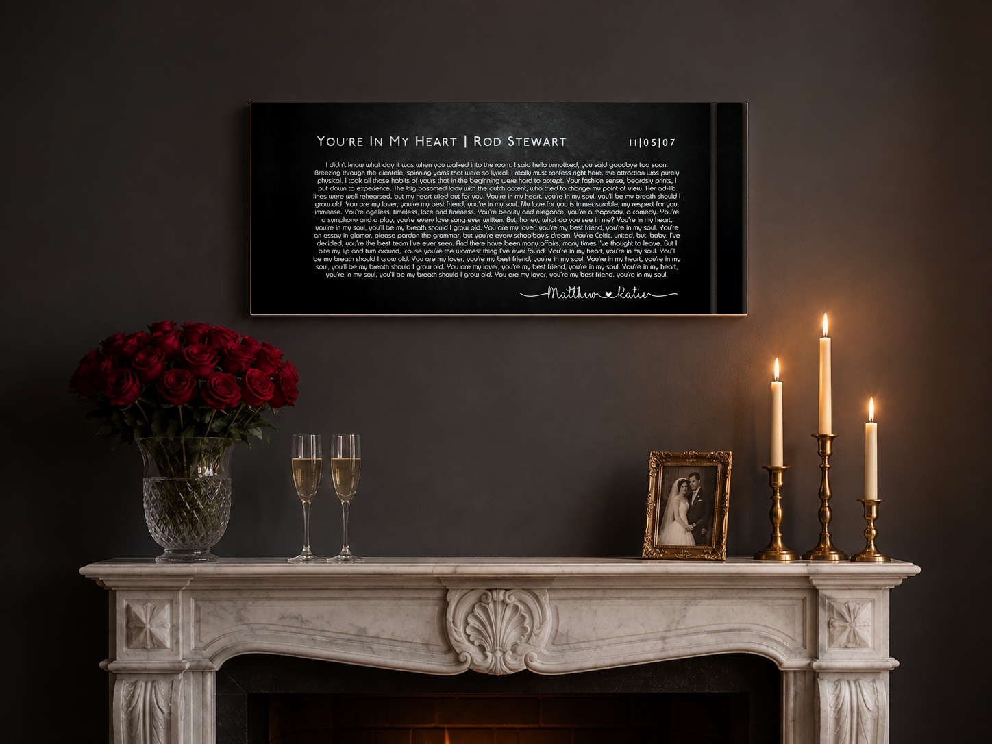 Anniversary song lyric canvas above a marble mantel with red roses, champagne flutes and brass candles