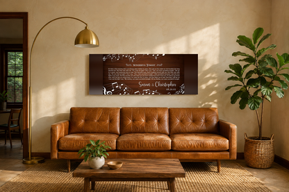 Custom song lyrics music notes canvas hanging above a caramel leather mid-century sofa in a warm cream living room