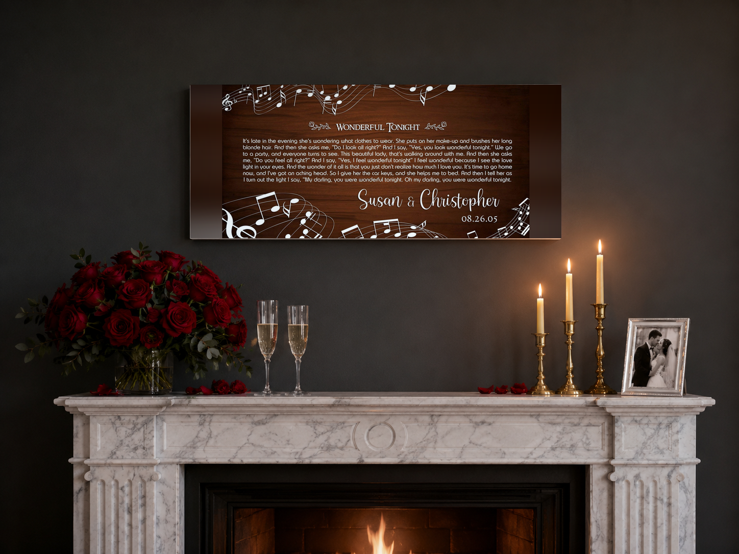Wedding anniversary song lyrics canvas above a marble fireplace mantel with red roses and champagne flutes