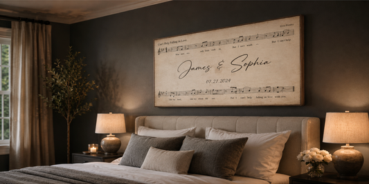 Personalized song lyrics canvas wall art hanging above a bed — 'Can't Help Falling in Love' by Elvis Presley sheet music personalized with the couple's names James & Sophia and wedding date 07.21.2024, framed print on a charcoal bedroom wall, first dance anniversary and wedding gift for couples