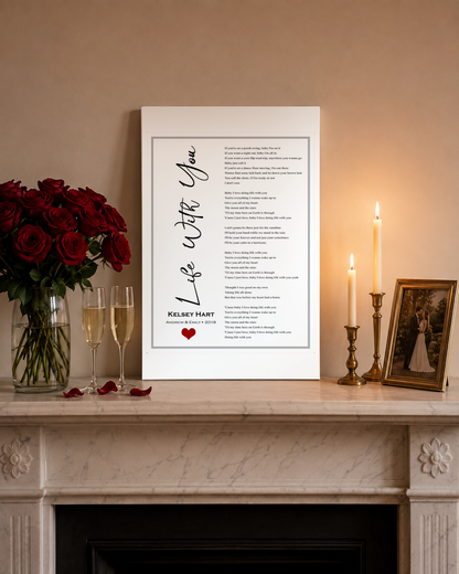 First dance song lyrics canvas on a marble mantel with red roses, champagne and candles for an anniversary